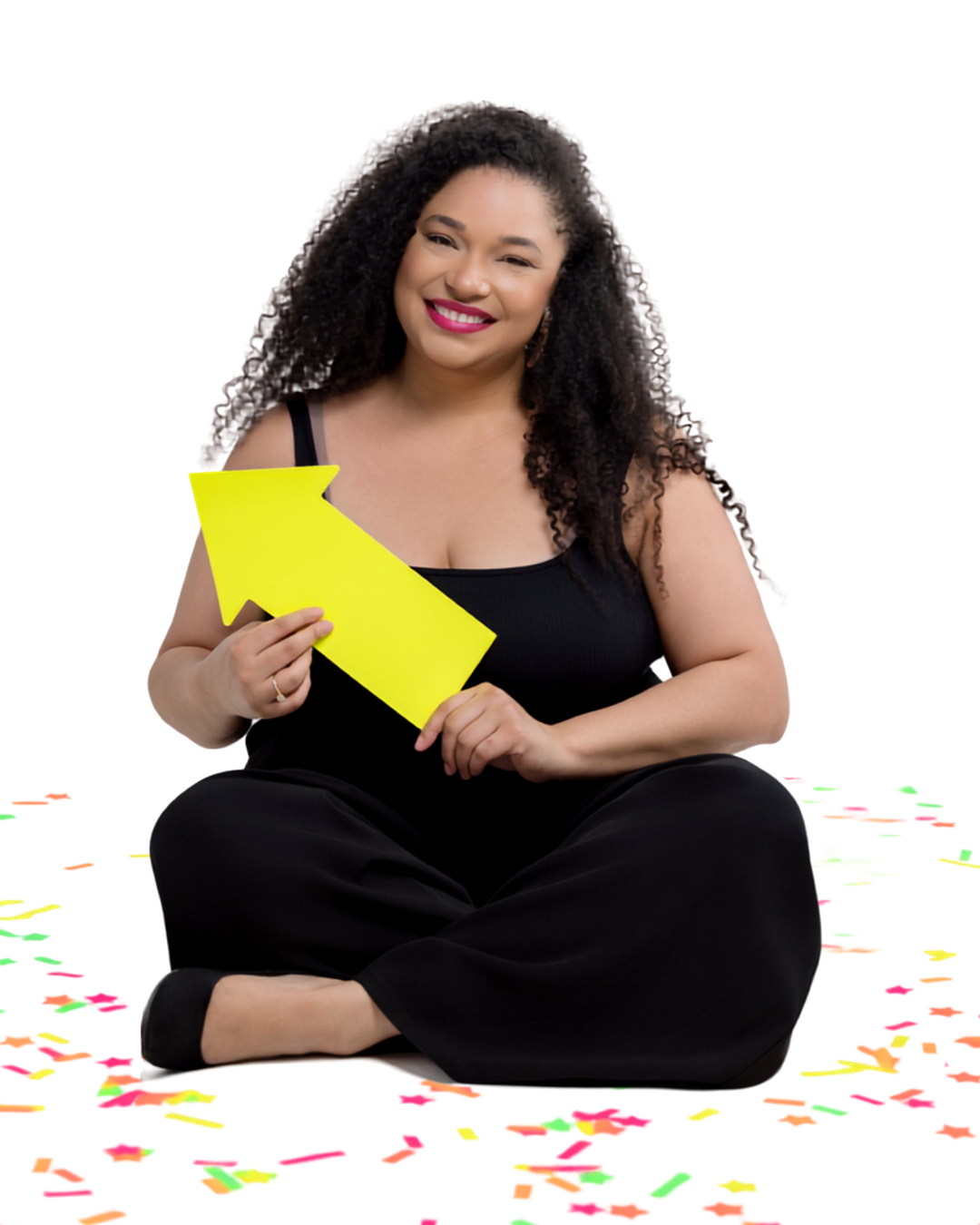 Jillian Thomas holding a pink arrow, sitting cross-legged with confetti
